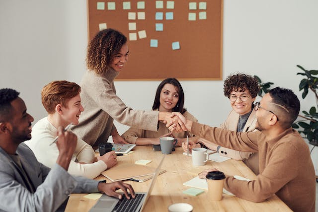 group of business professionals in a meeting shaking hands