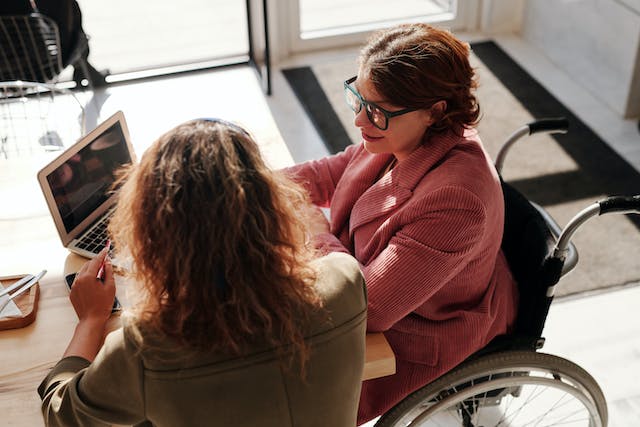 two people at a table one of them in a wheelchair